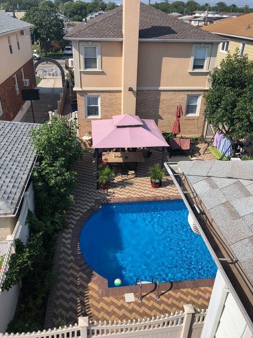 An aerial view of a backyard with a large swimming pool