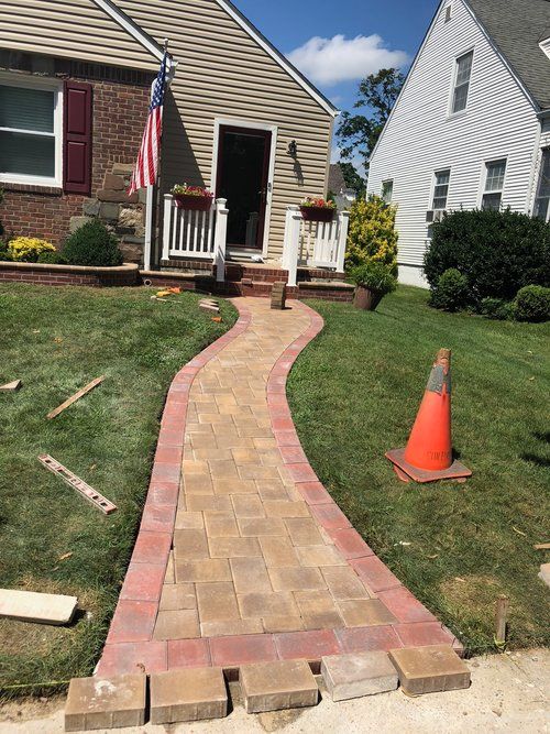 A brick walkway is being built in front of a house.
