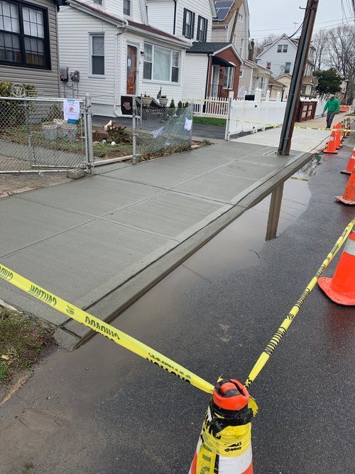 A concrete sidewalk is being built in front of a house.