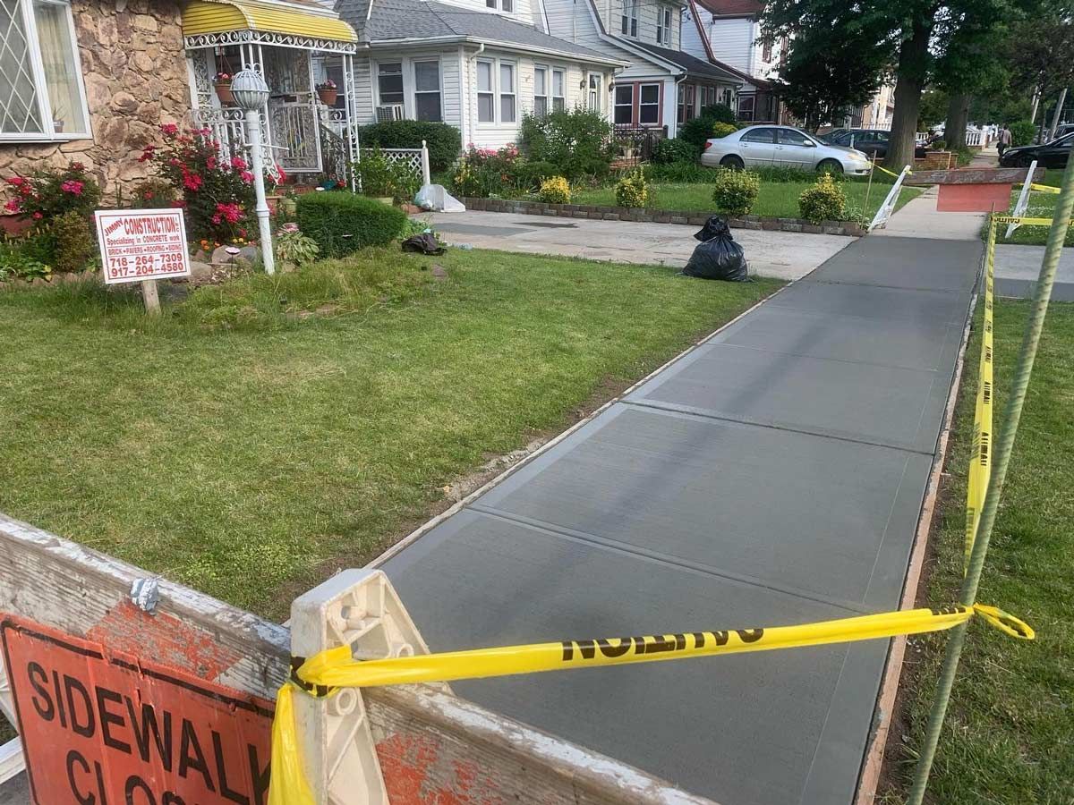 A sidewalk is being built in front of a house.