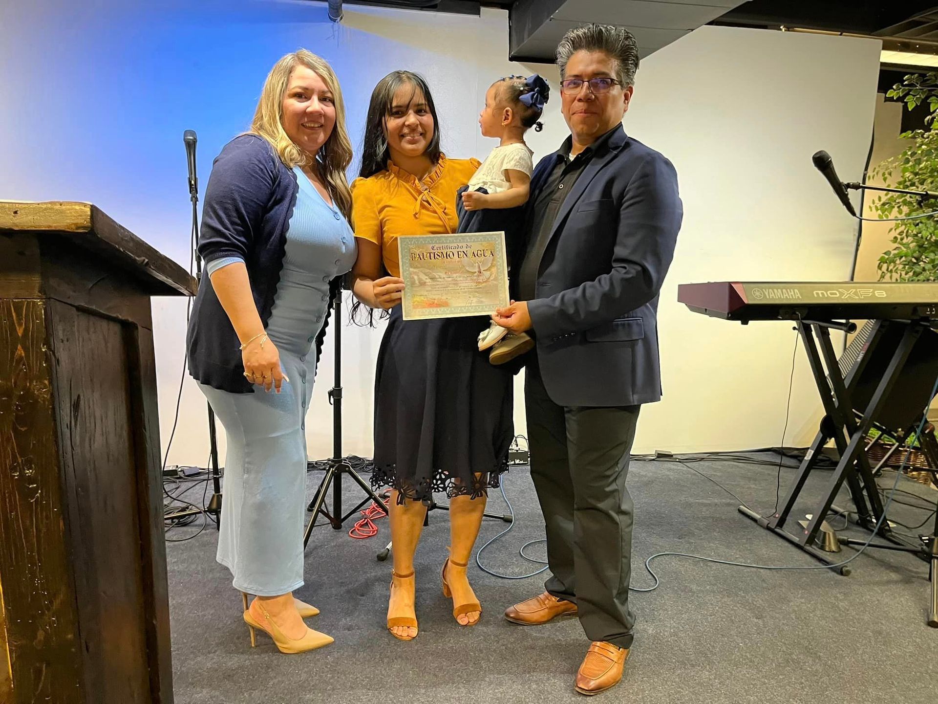Un grupo de personas paradas una al lado de la otra en una habitación sosteniendo un certificado.