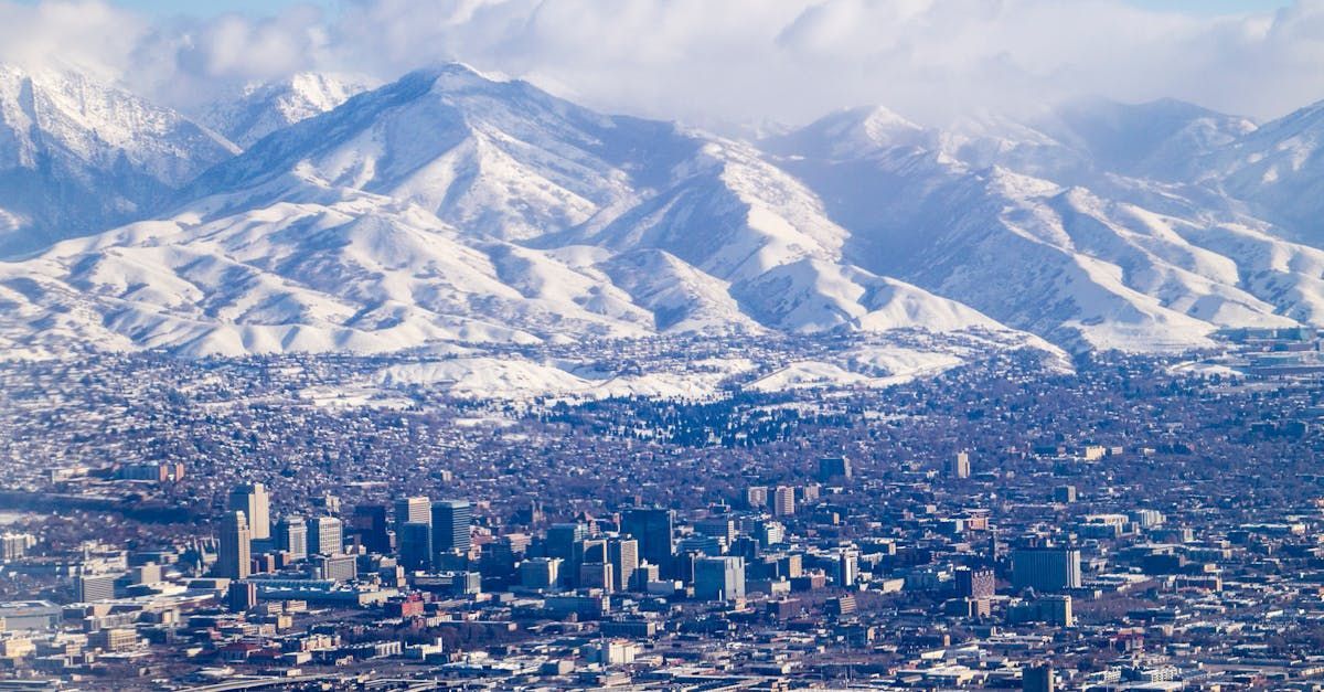 Una vista aérea de una ciudad con montañas cubiertas de nieve al fondo.