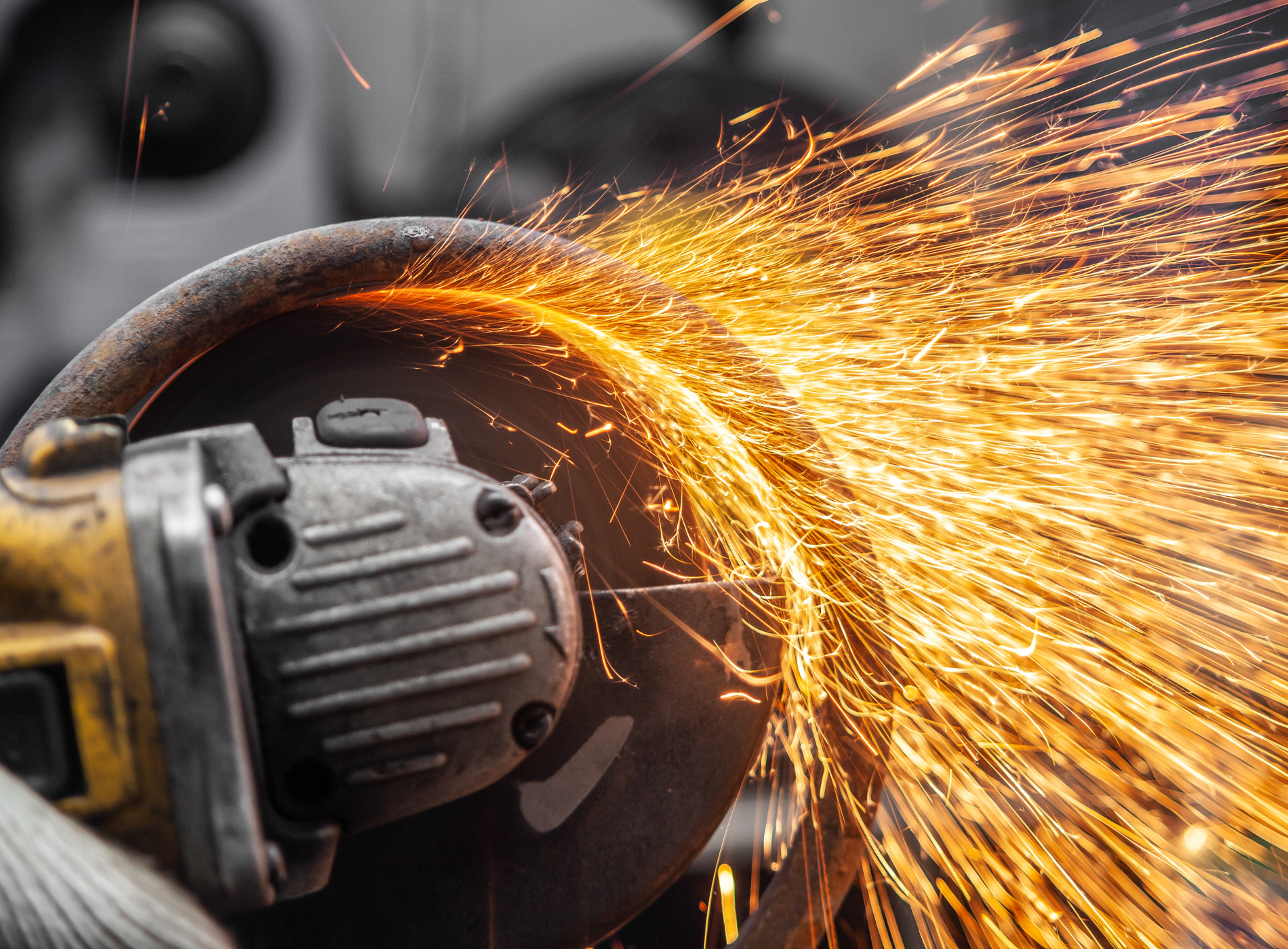 A person is using a grinder to cut a piece of metal.