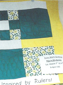 A stained glass applique square with a blue and black design on it.