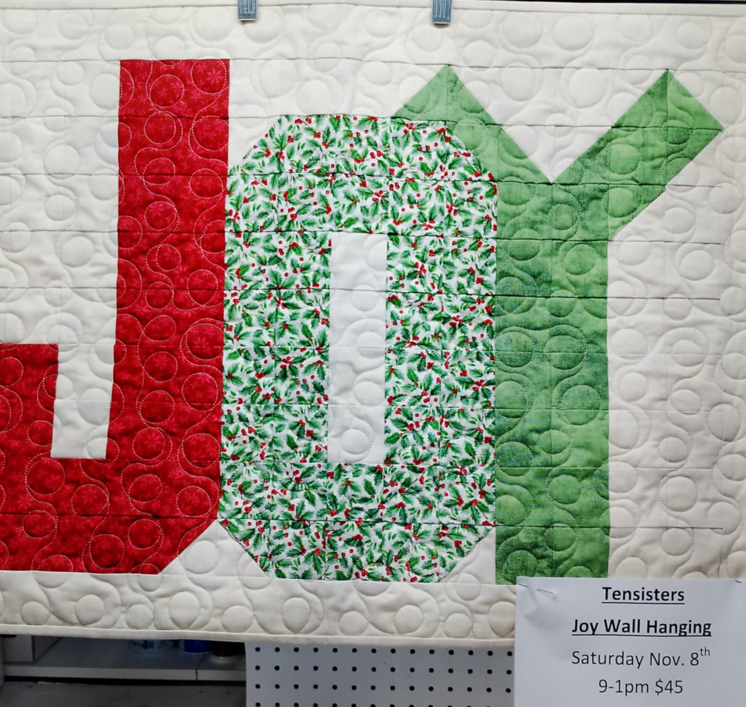Quilted orange pumpkin with a carved face on blue background.