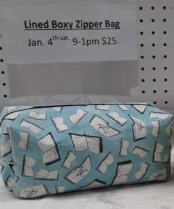 A lined boxy zipper bag is sitting on a table.