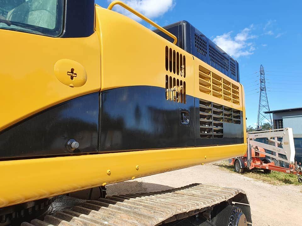 A Yellow and Black Excavator is Parked on a Dirt Road — Waters Abrasive Blasting Services In Shaw, QLD