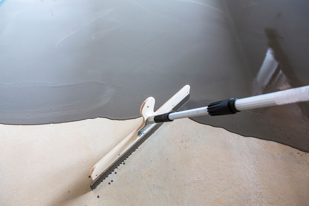 Applying a Grey Epoxy Coating Over a Concrete Surface — Waters Abrasive Blasting Services in Shaw, QLD