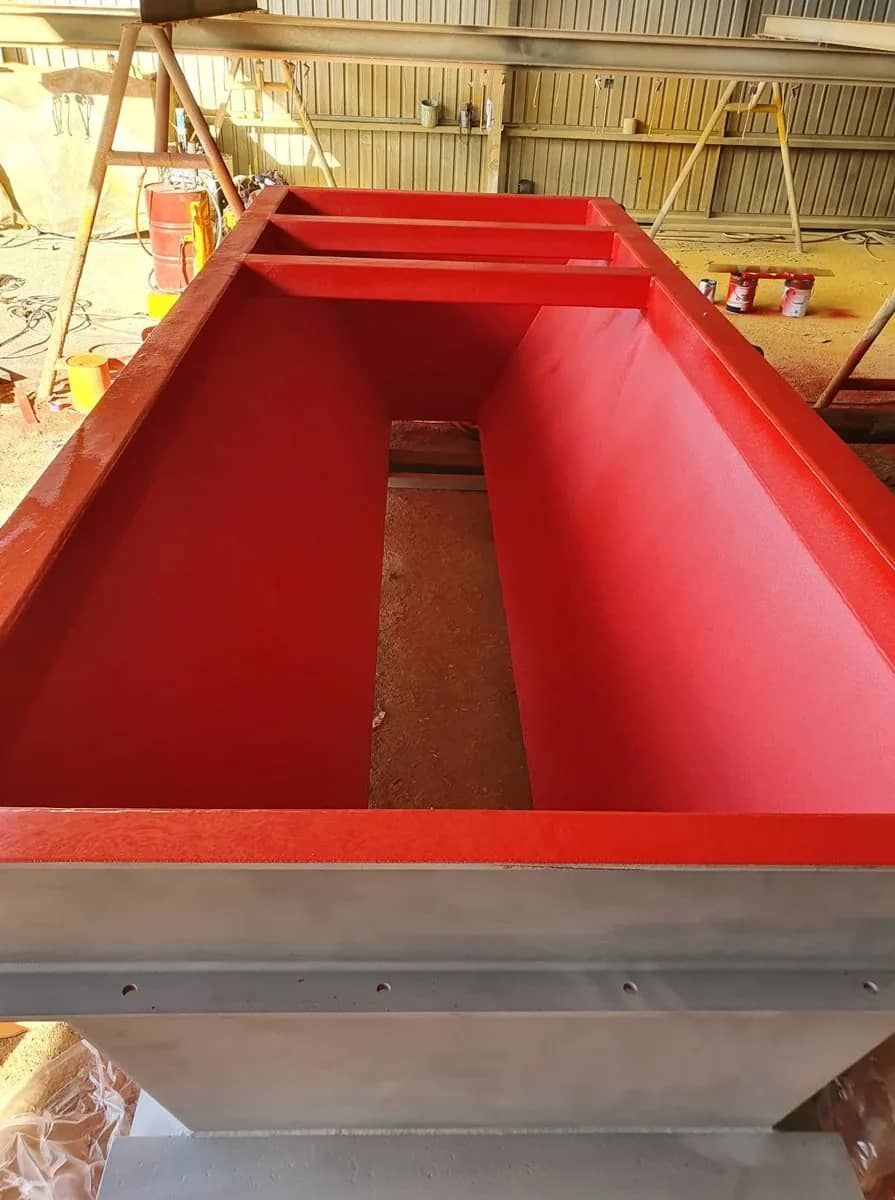 A Large Red Box is Sitting on a Table in a Warehouse — Waters Abrasive Blasting Services In Shaw, QLD