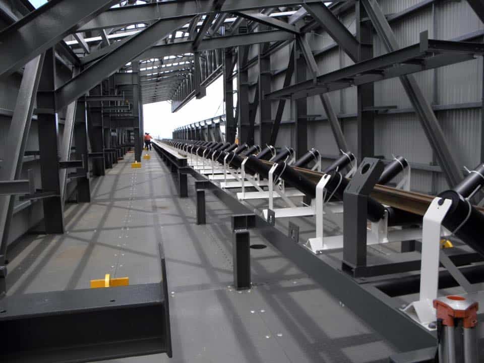 A Large Metal Structure With a Conveyor Belt Going Through It — Waters Abrasive Blasting Services In Shaw, QLD