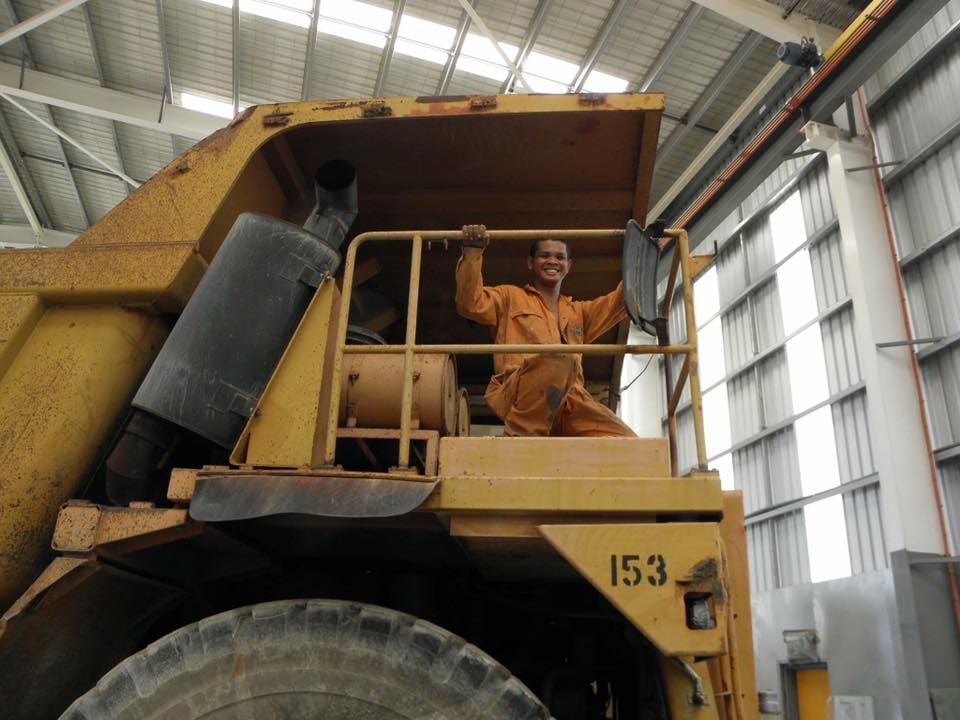 A Man is Sitting in the Cab of a Dump Truck With the Number 153 on the Side — Waters Abrasive Blasting Services In Shaw, QLD
