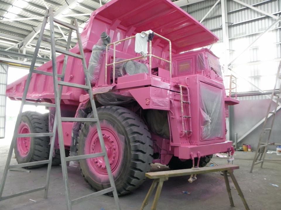 A Pink Dump Truck is Being Painted in a Warehouse — Waters Abrasive Blasting Services In Shaw, QLD