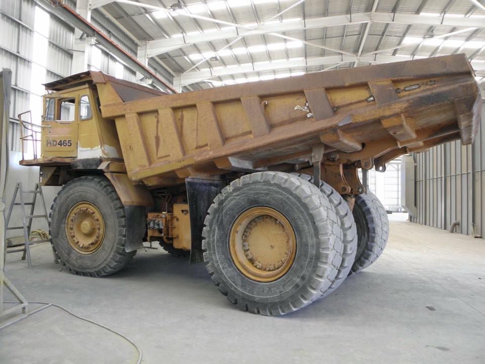 A Large Dump Truck is Parked in a Warehouse — Waters Abrasive Blasting Services In Shaw, QLD