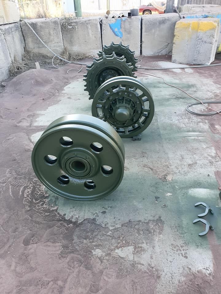 Three Green Wheels Are Sitting on a Concrete Surface — Waters Abrasive Blasting Services In Mackay, QLD