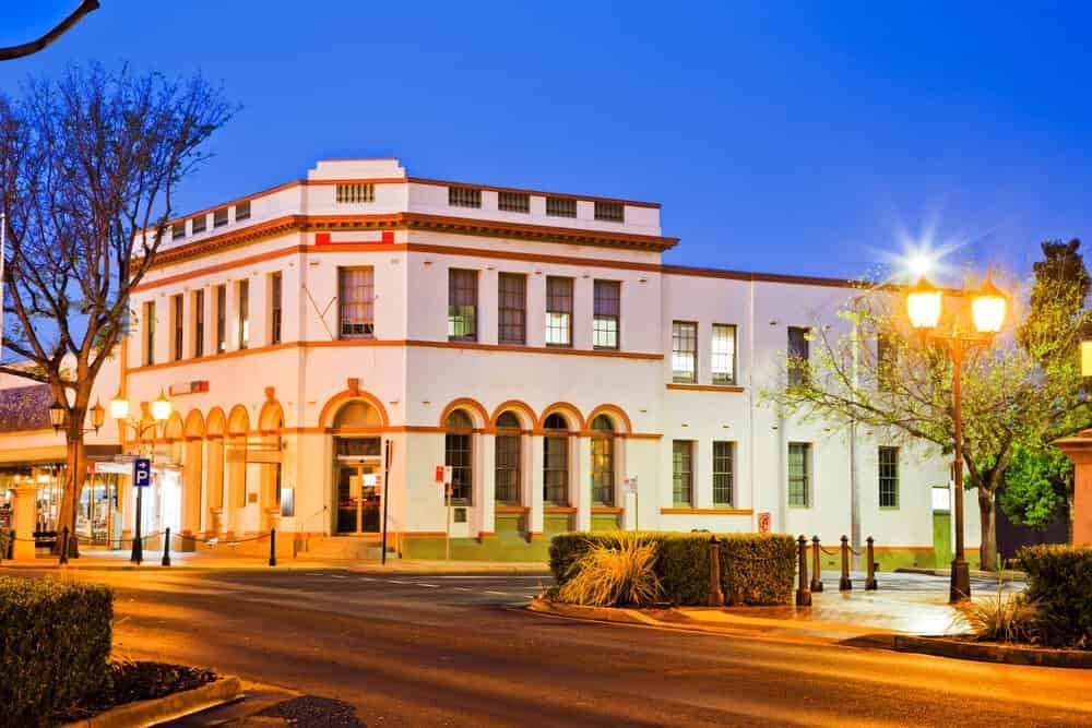 A Large White Building is Sitting on the Corner of a Street at Night — Waters Abrasive Blasting Services In Shaw, QLD
