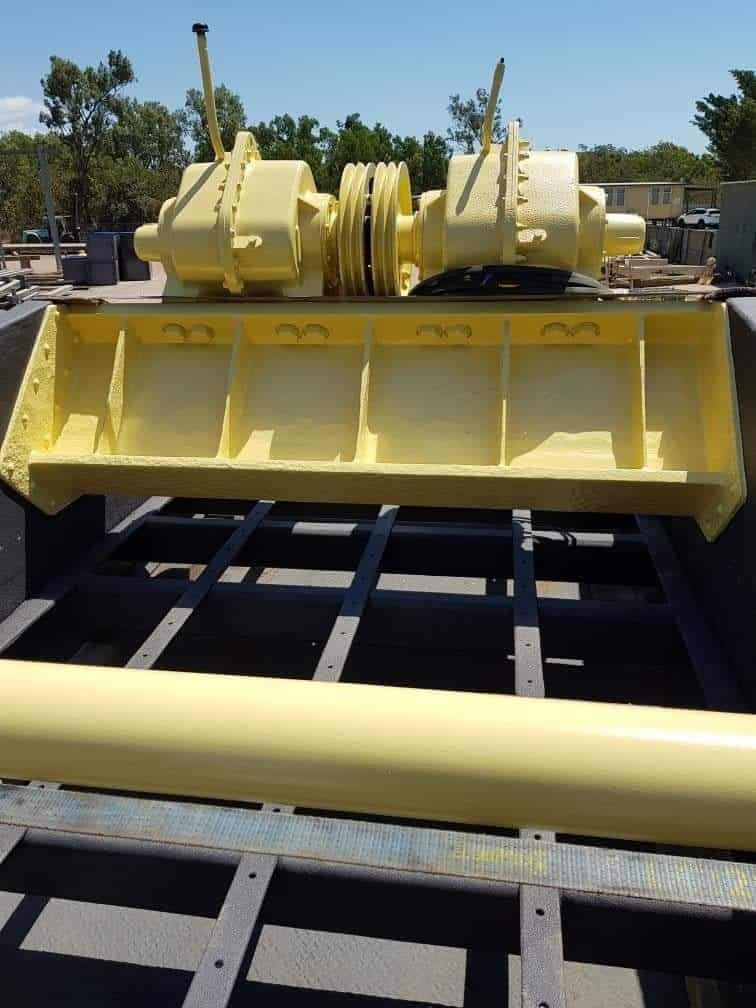 A Yellow Machine is Sitting on Top of a Concrete Surface — Waters Abrasive Blasting Services In Shaw, QLD