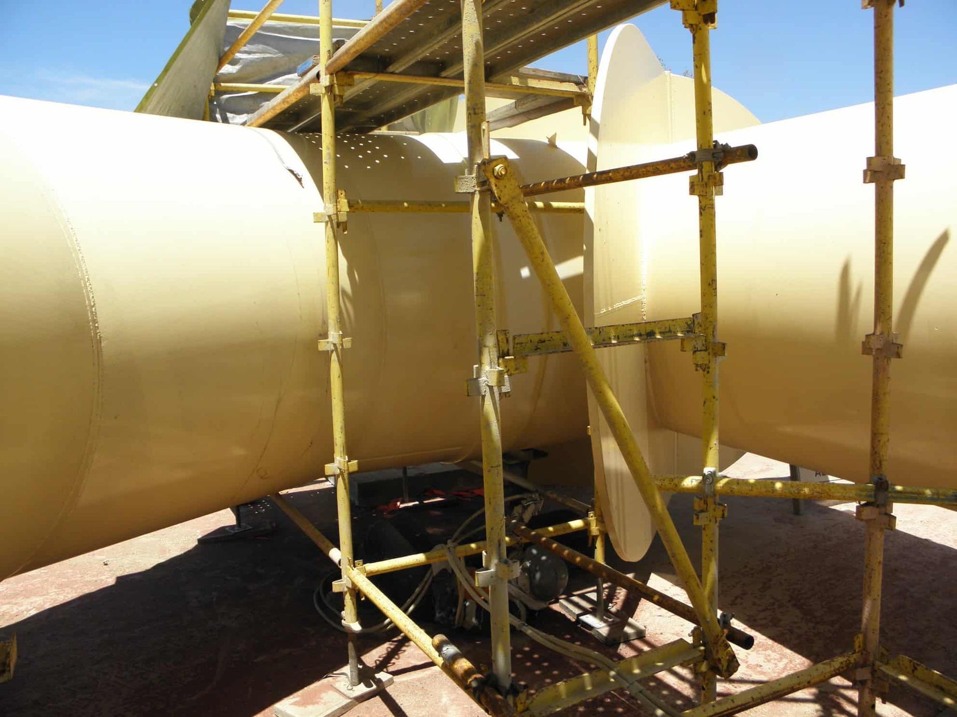 A Large Yellow Pipe is Sitting on Top of a Yellow Scaffolding — Waters Abrasive Blasting Services In Shaw, QLD