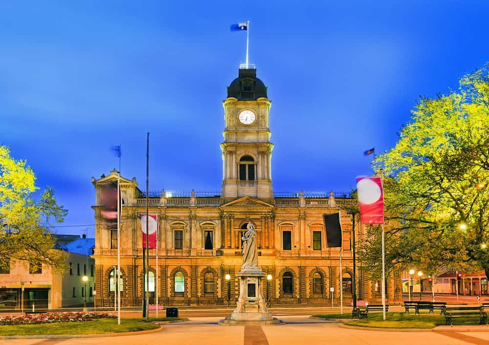 A Large Building With a Clock Tower and a Statue in Front of It — Waters Abrasive Blasting Services In Shaw, QLD