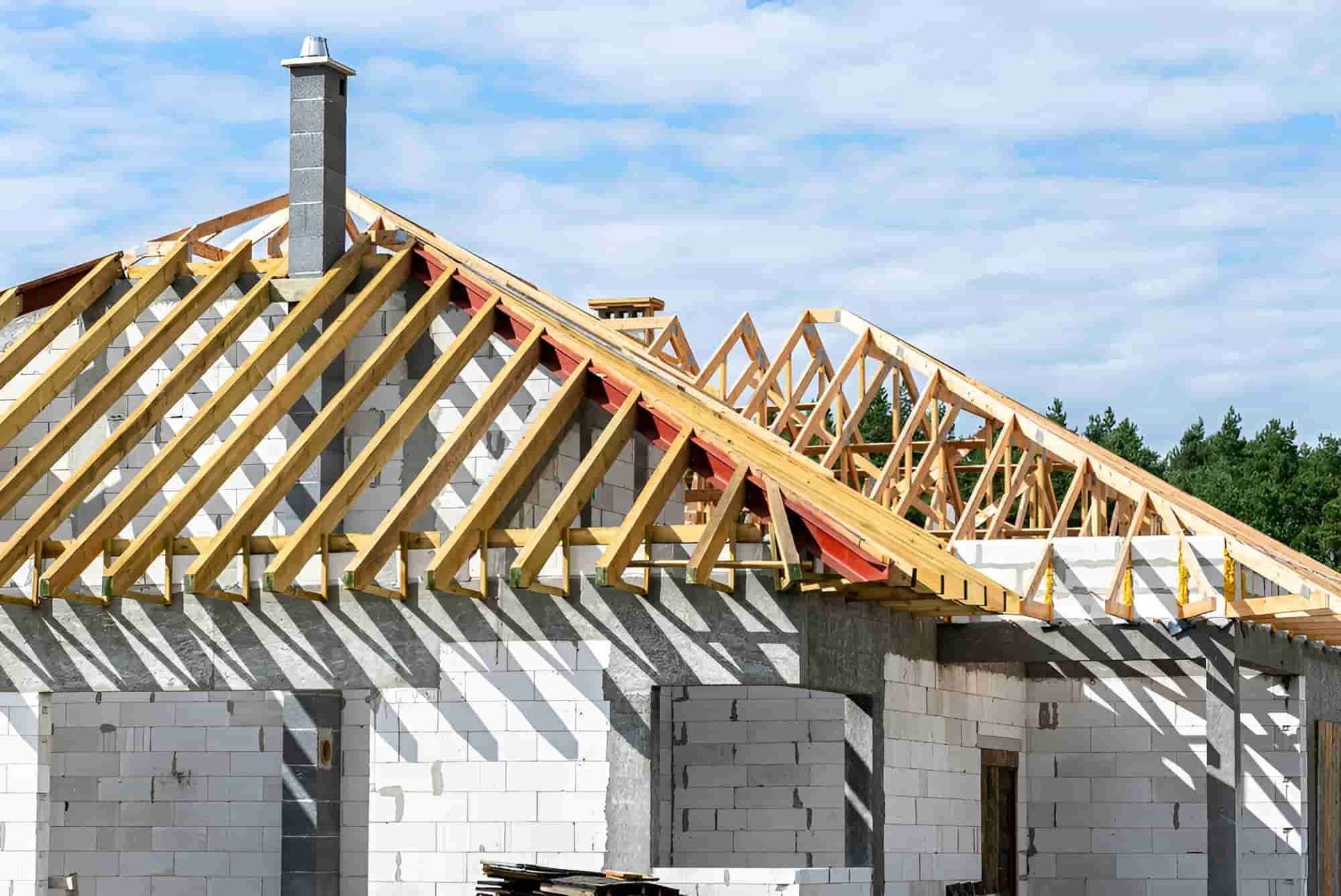 The Roof of a House is Being Built With Wooden Beams — Waters Abrasive Blasting Services In Shaw, QLD