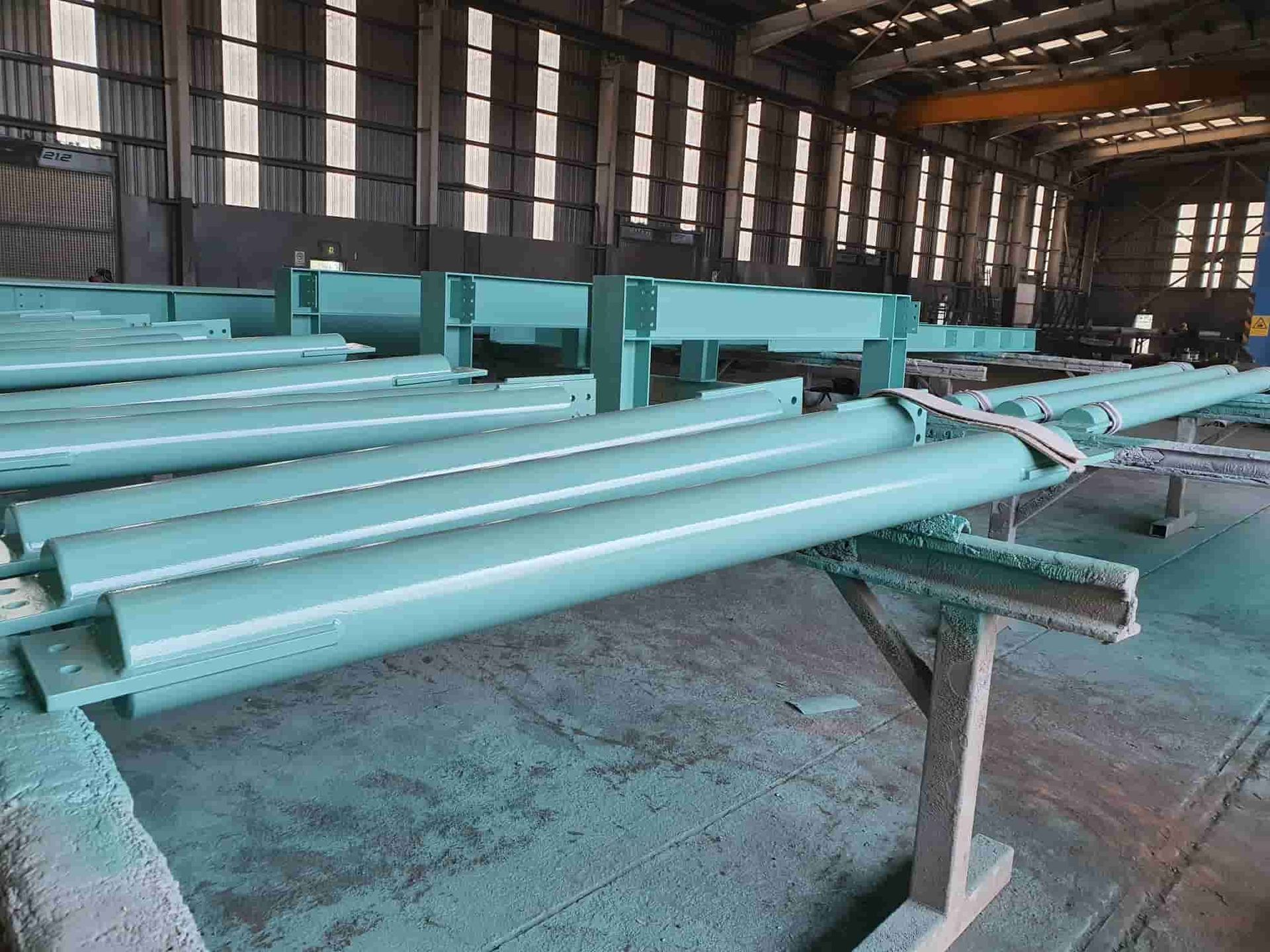 A Bunch of Green Pipes Are Sitting on a Table in a Factory — Waters Abrasive Blasting Services In Shaw, QLD