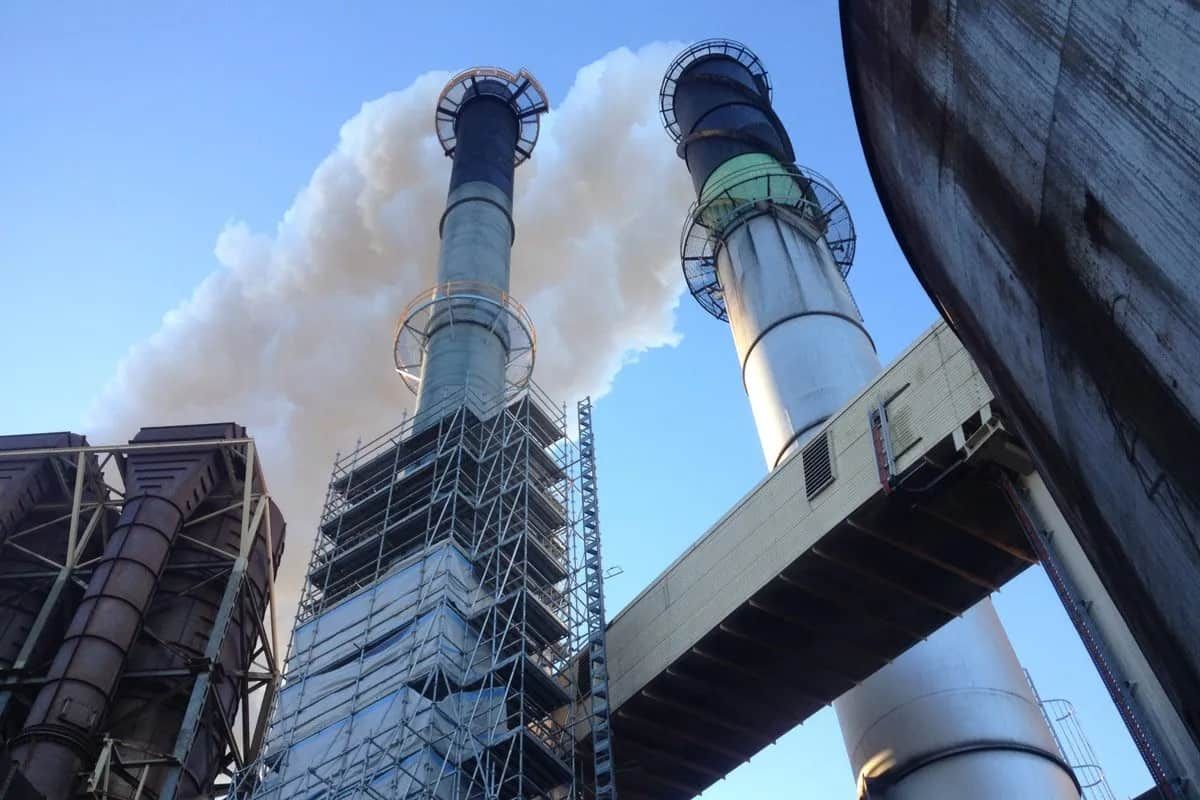 Smoke is Coming Out of the Chimneys of a Factory — Waters Abrasive Blasting Services In Shaw, QLD