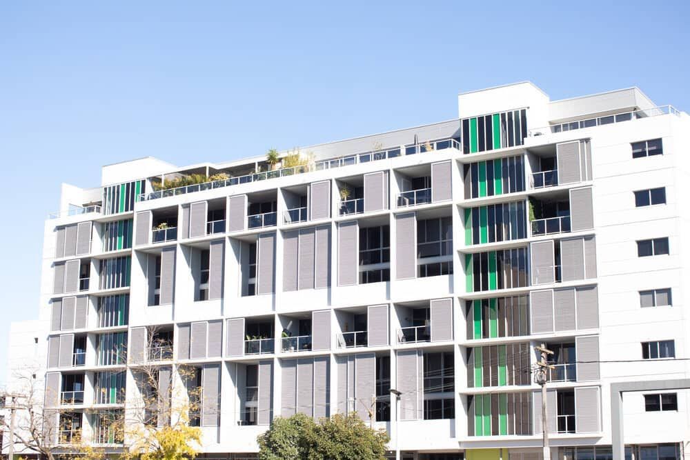 A Large Building With a Lot of Windows and Balconies on a Sunny Day — Waters Abrasive Blasting Services In Shaw, QLD