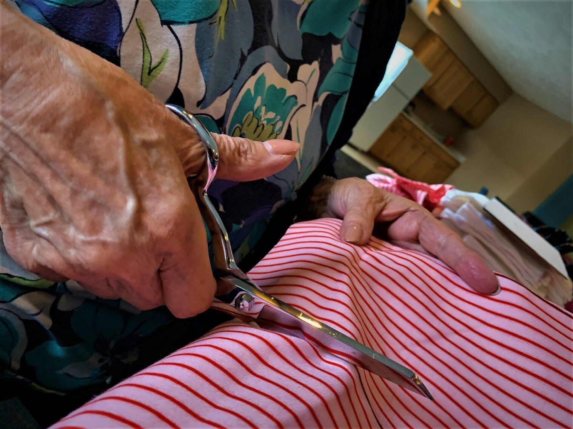 Elderly Woman Using Sheers to Cut Striped Fabric