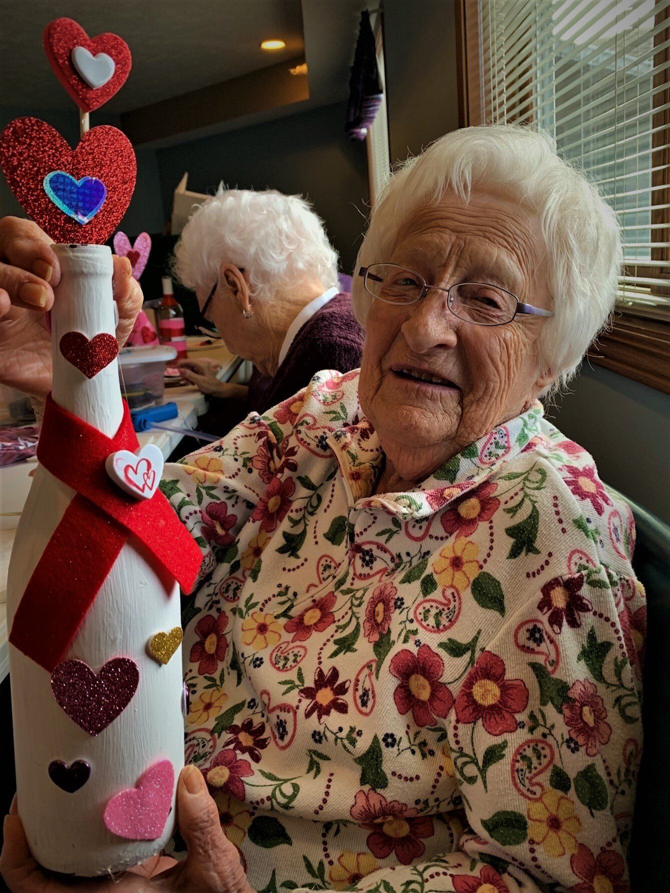 Happy Senior Showing Off Valentine's Wine Bottle Craft
