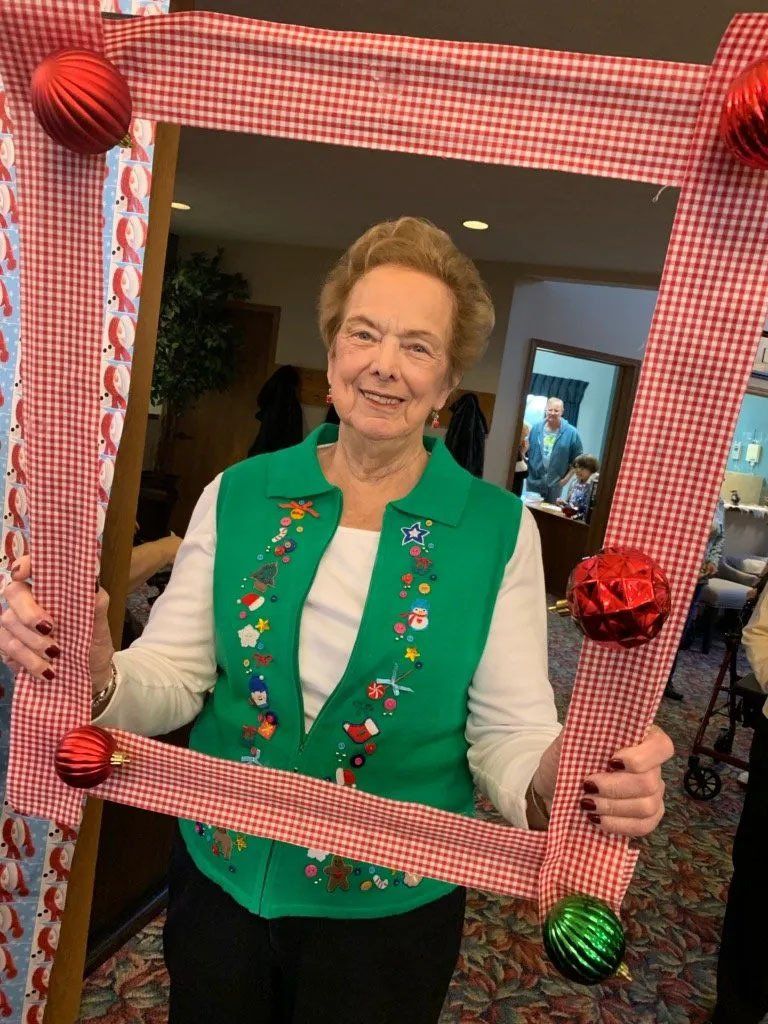 Woman in Christmas Vest Posing with Handheld Ornament Frame