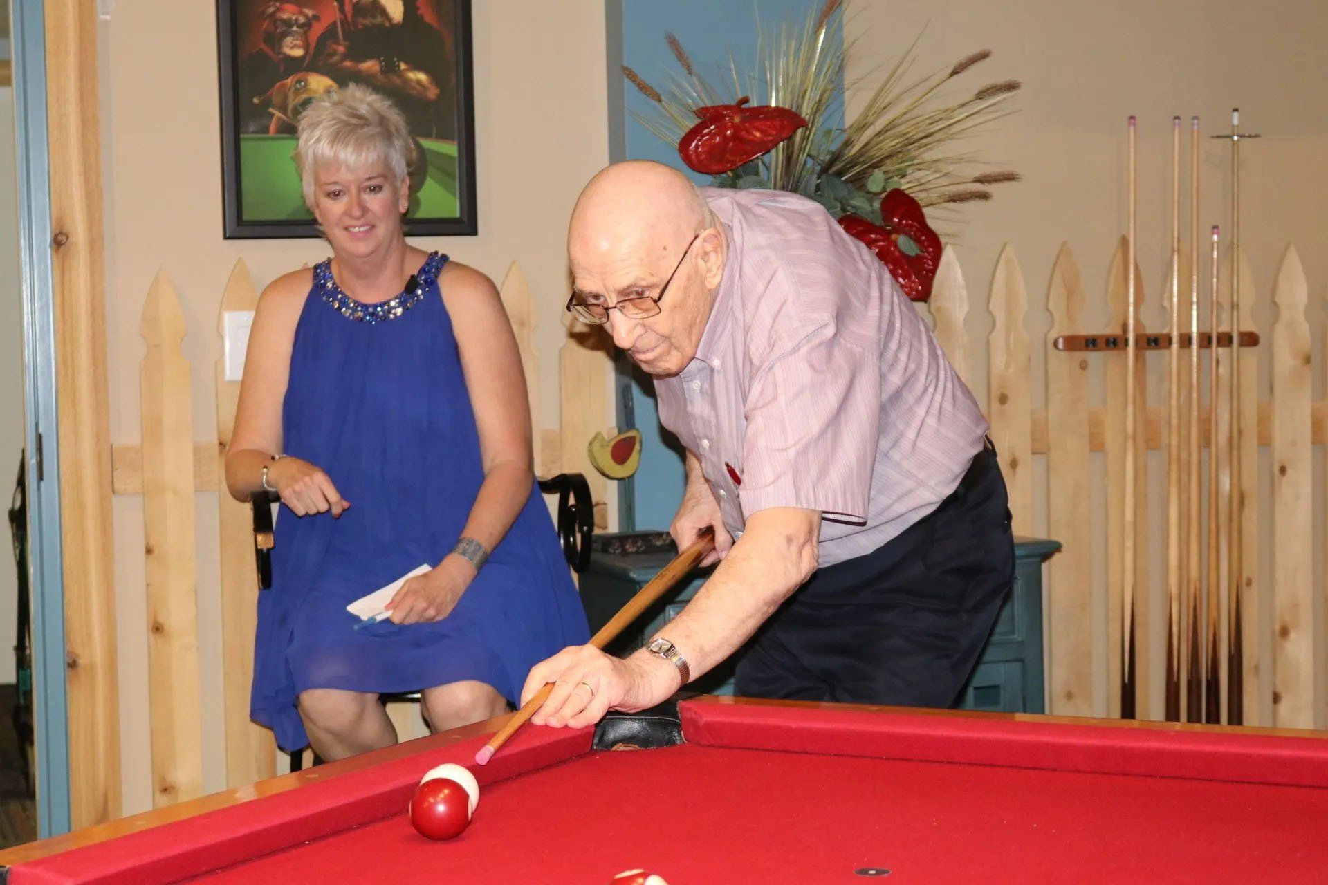 Senior Male Playing Pool While Female Watches