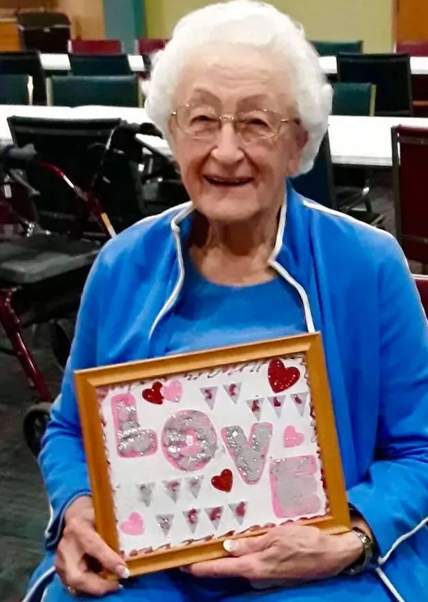 Happy Senior Displaying Valentine's Day Craft