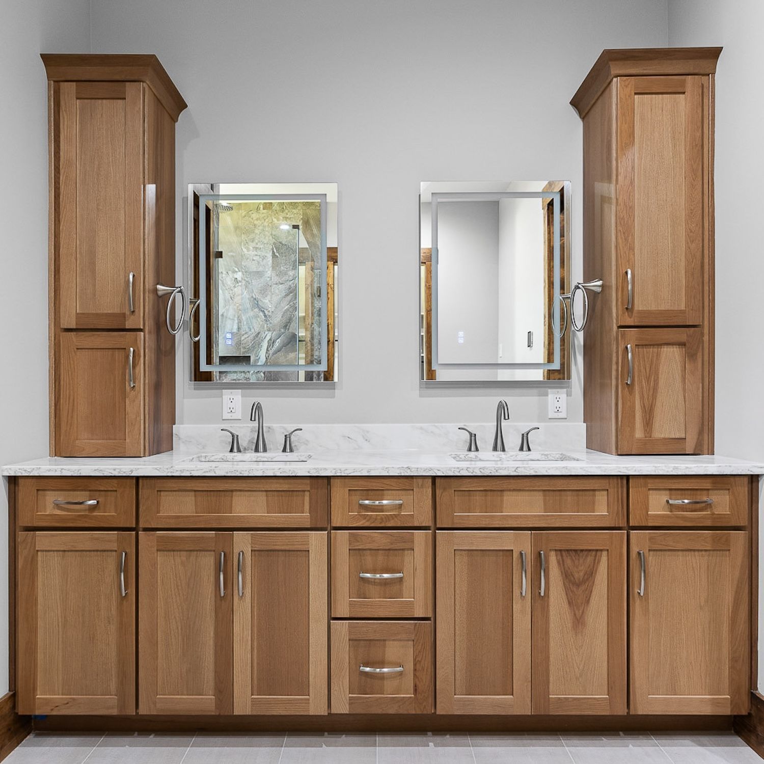 Bathroom with two sinks, mirrors, and wooden cabinets.