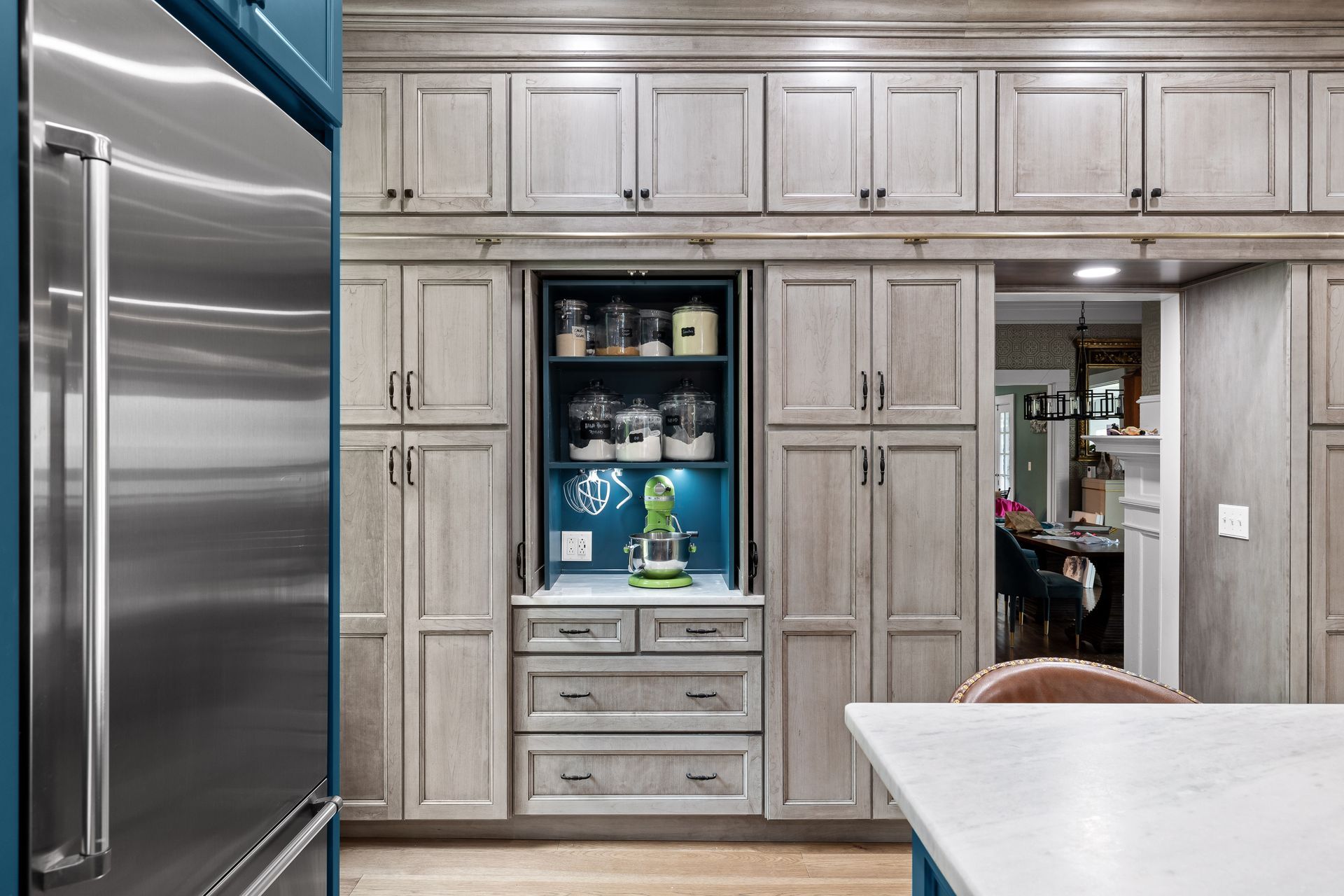 Kitchen with light gray cabinets, blue accents, and a stainless steel refrigerator.