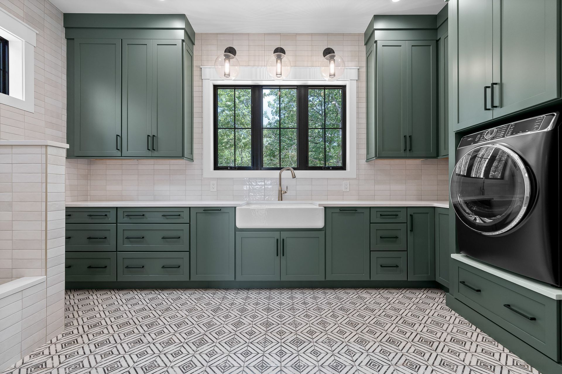 Green laundry room with cabinets, patterned floor, black window, and washer.