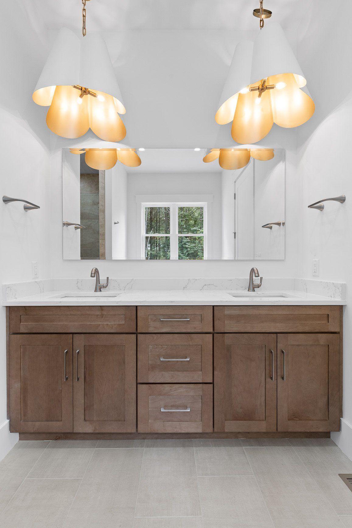 Bathroom with a double vanity, large mirror, and two decorative pendant lights.