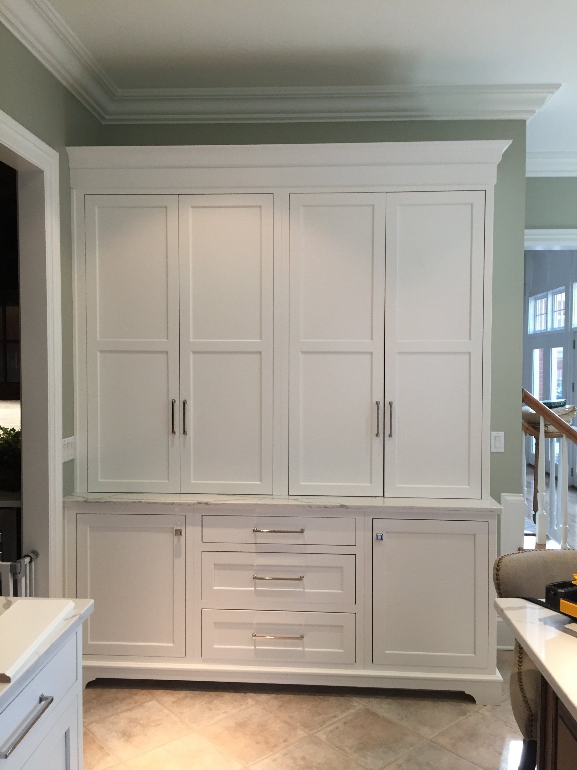 A kitchen with lots of white cabinets and drawers
