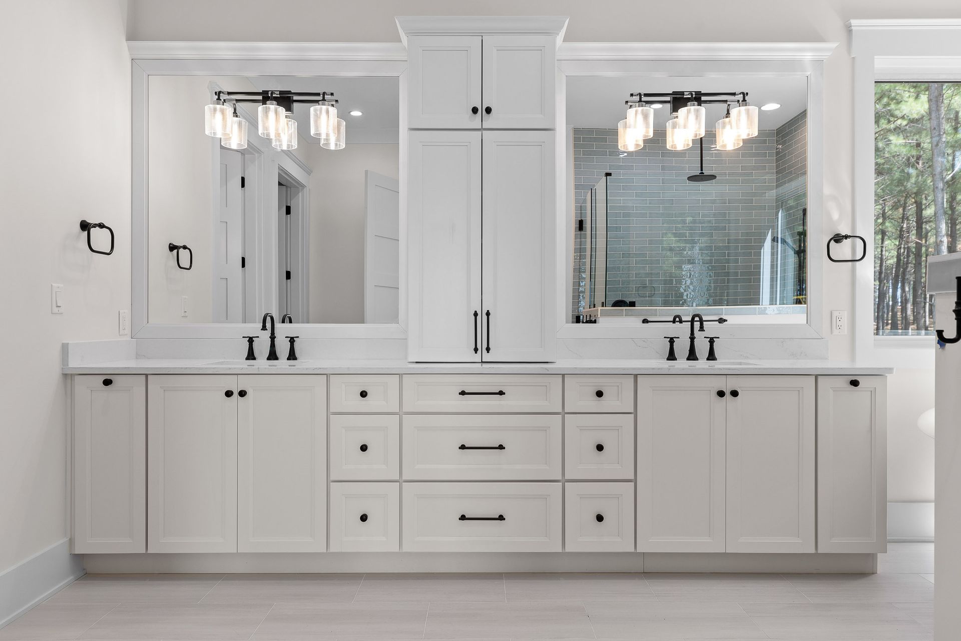 White bathroom vanity with mirrors, lights, and black fixtures.