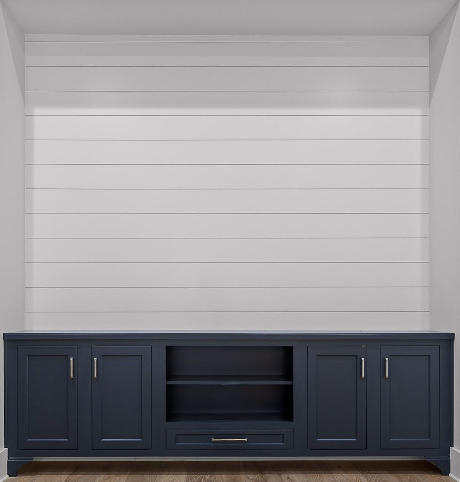 Navy blue entertainment center with cabinets and shelving against a white shiplap wall.