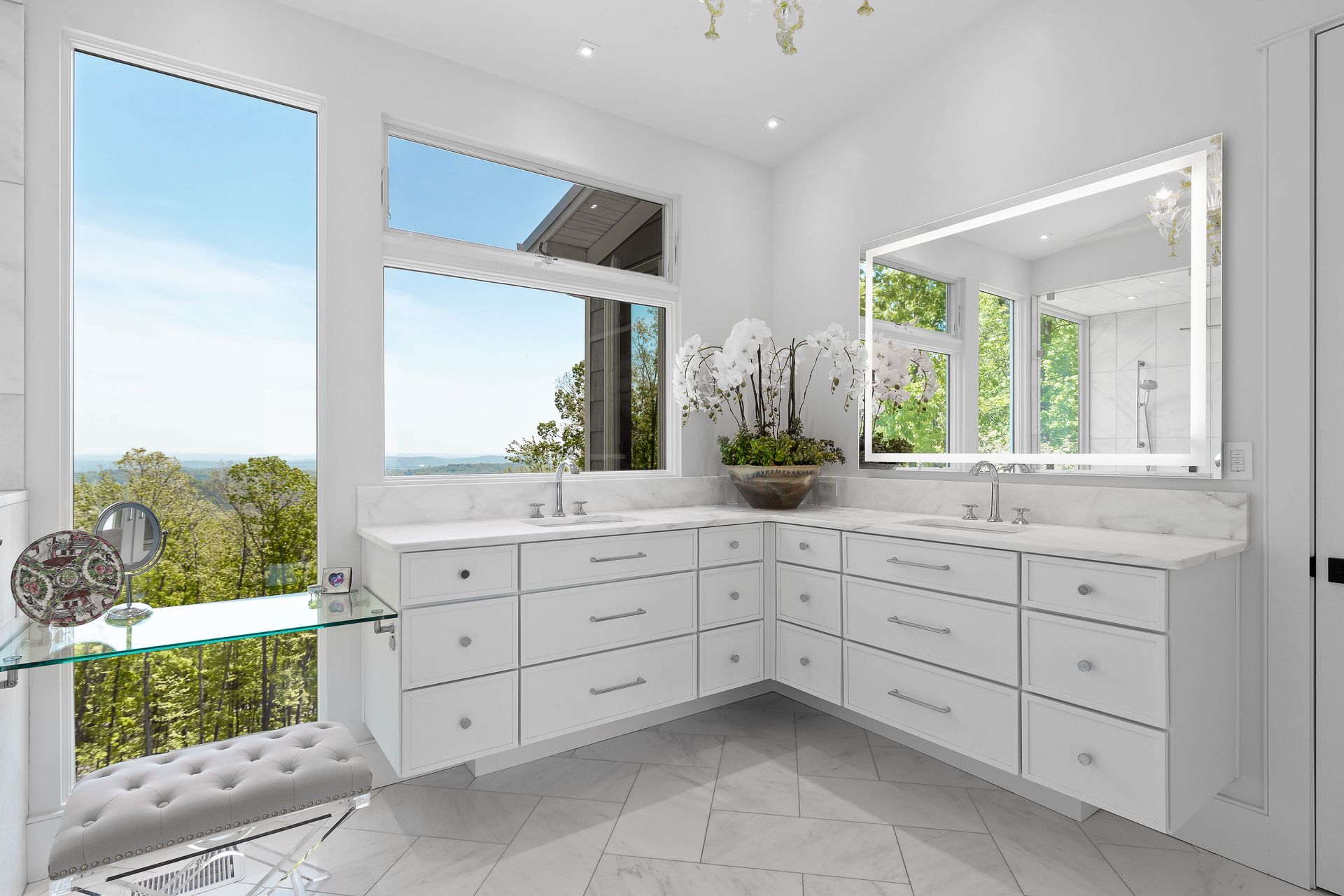 White luxury bathroom with large windows, vanity, and scenic view.