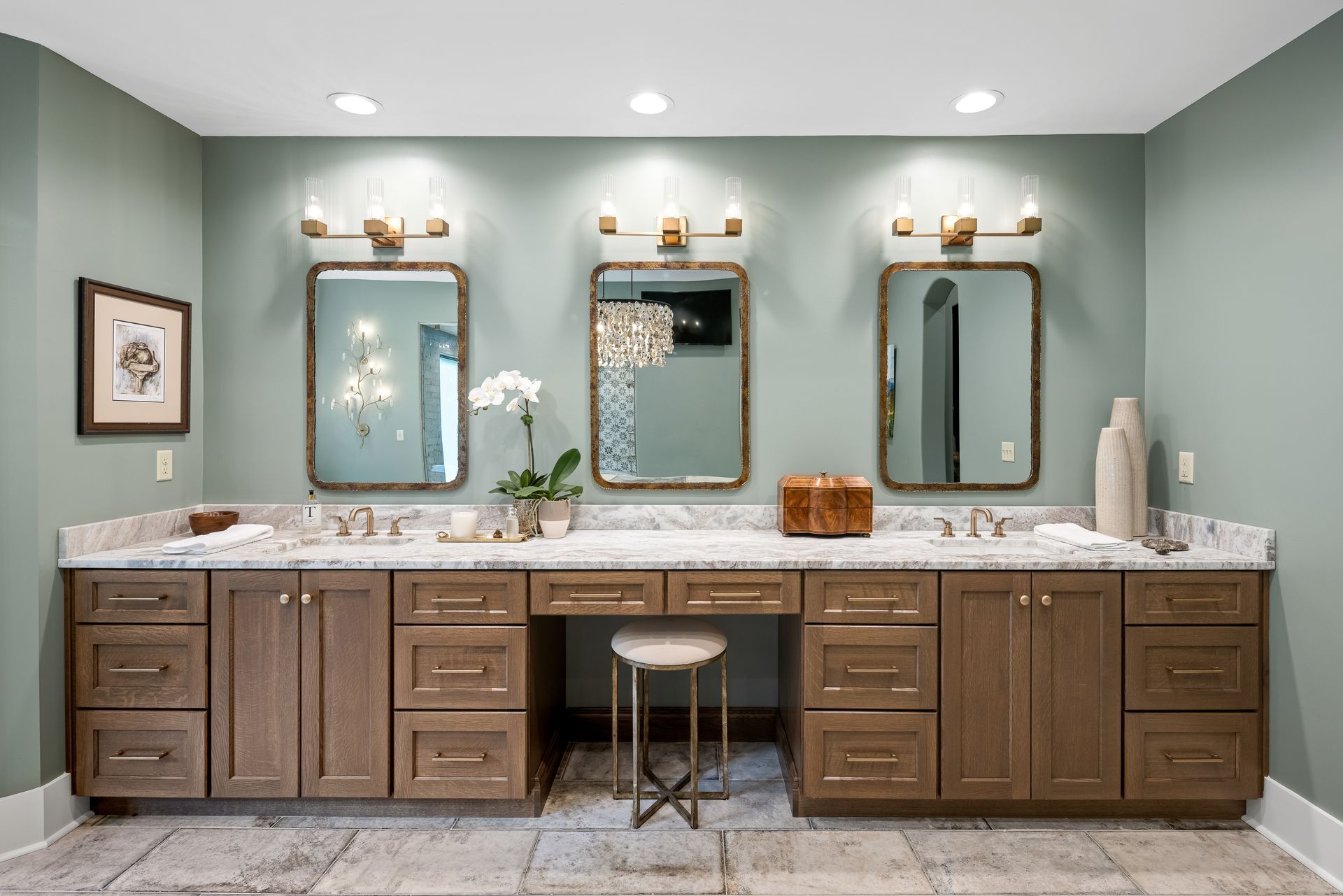 A spacious bathroom with three vanity mirrors, brown cabinets, and a light blue wall.