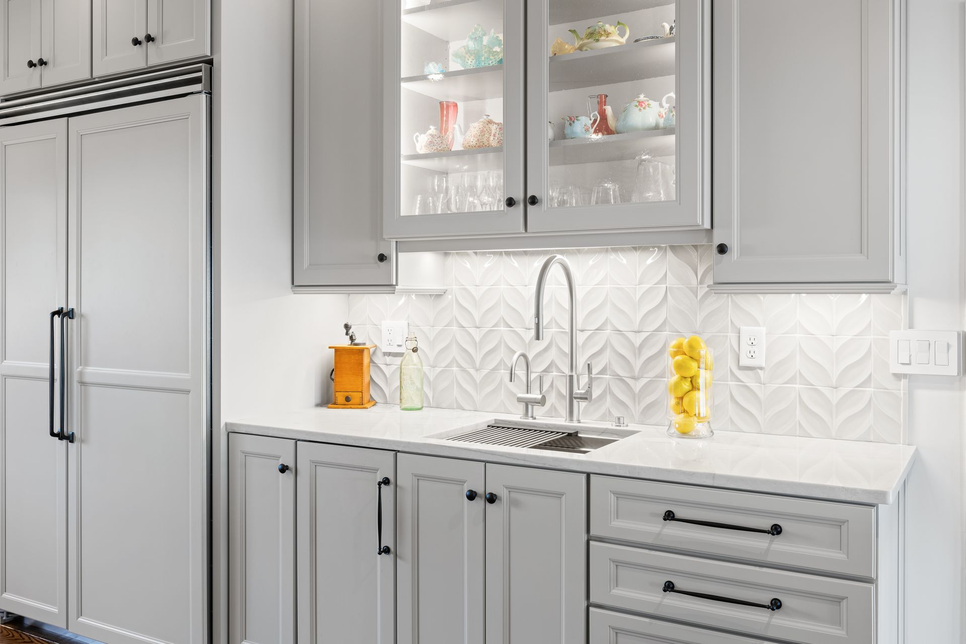 White kitchen with sink, cabinets, and glass-door display; backlit.