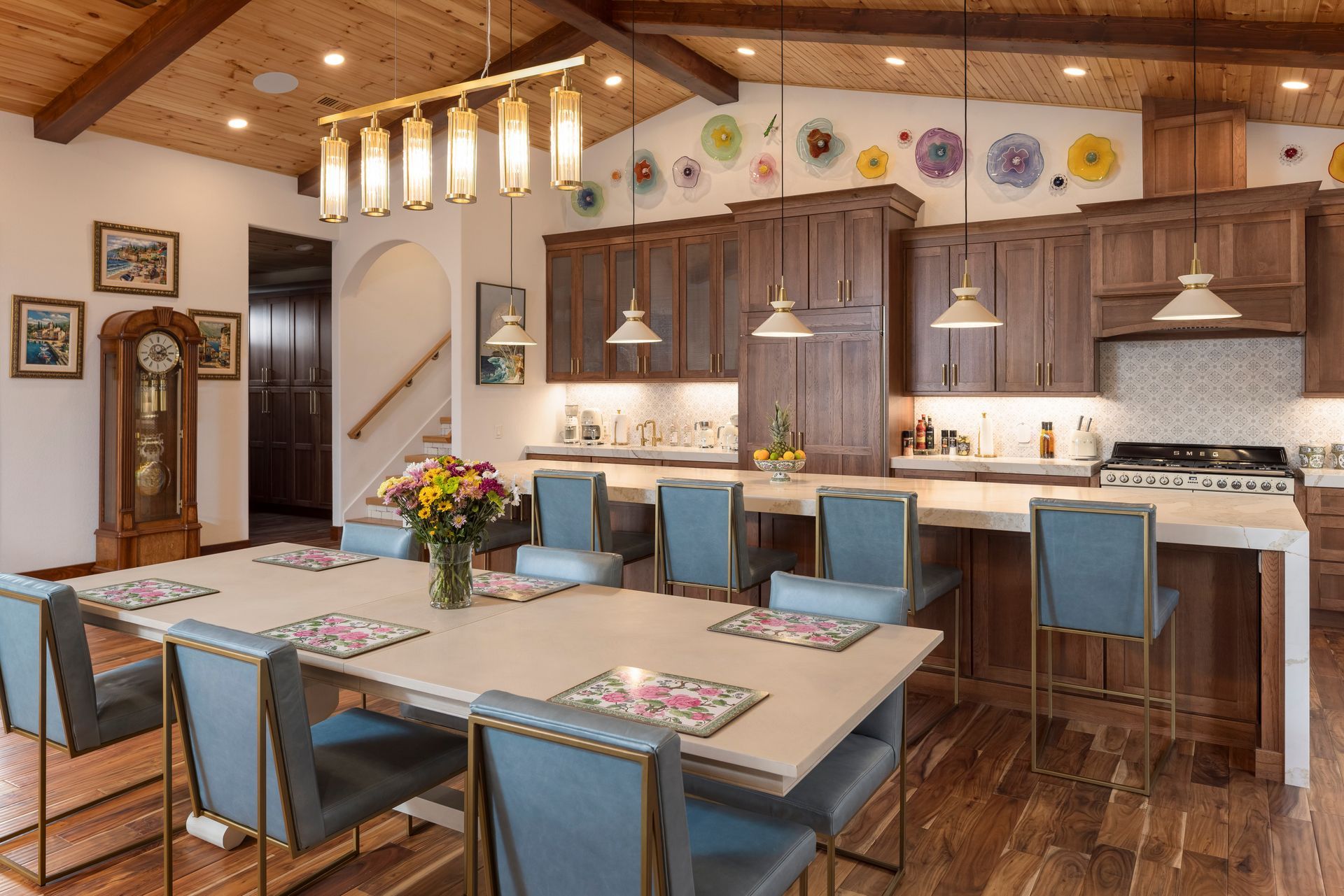 Spacious kitchen and dining area with wood cabinets, a long table, and blue chairs.