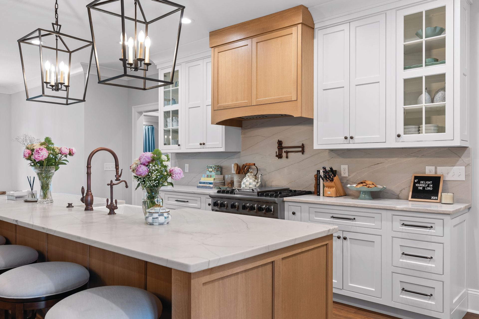 Kitchen with white cabinets, light wood accents, and an island with seating.