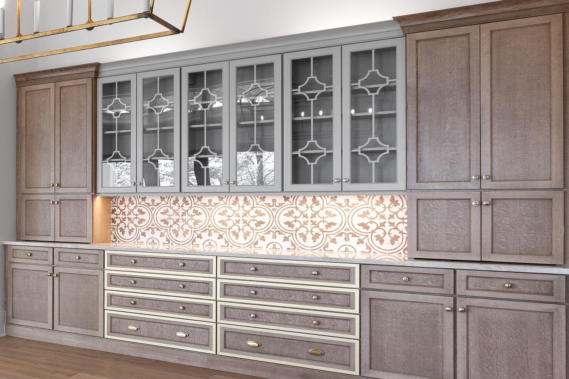 Kitchen cabinets with glass doors above drawers and cabinets, neutral colors.