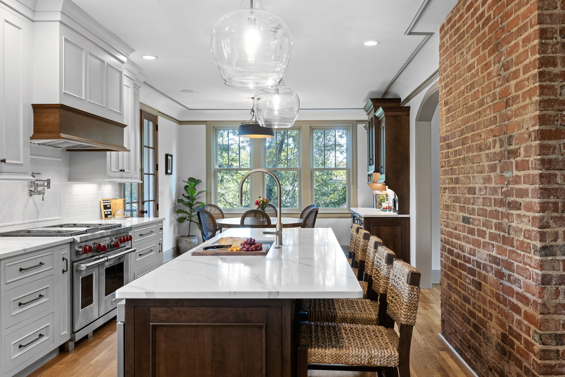 Modern kitchen with white cabinetry, island, and brick accent wall.