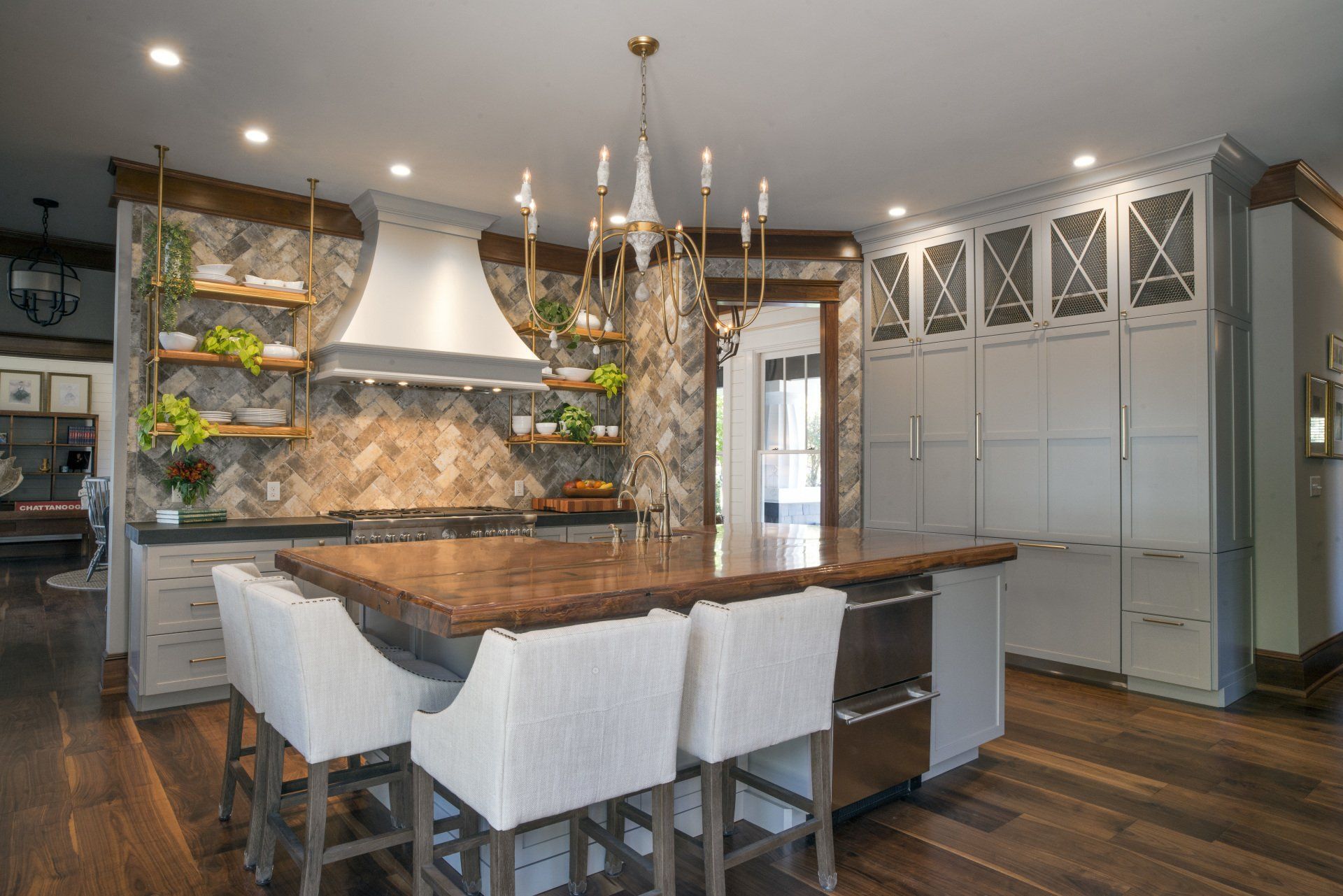 Kitchen with stone accent wall, island with seating, and modern lighting.