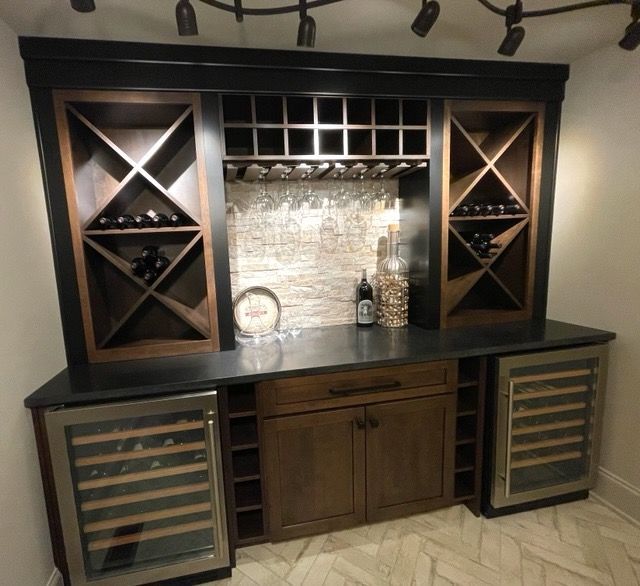 Wine bar with built-in coolers, storage, and racks; dark wood and stone accents.