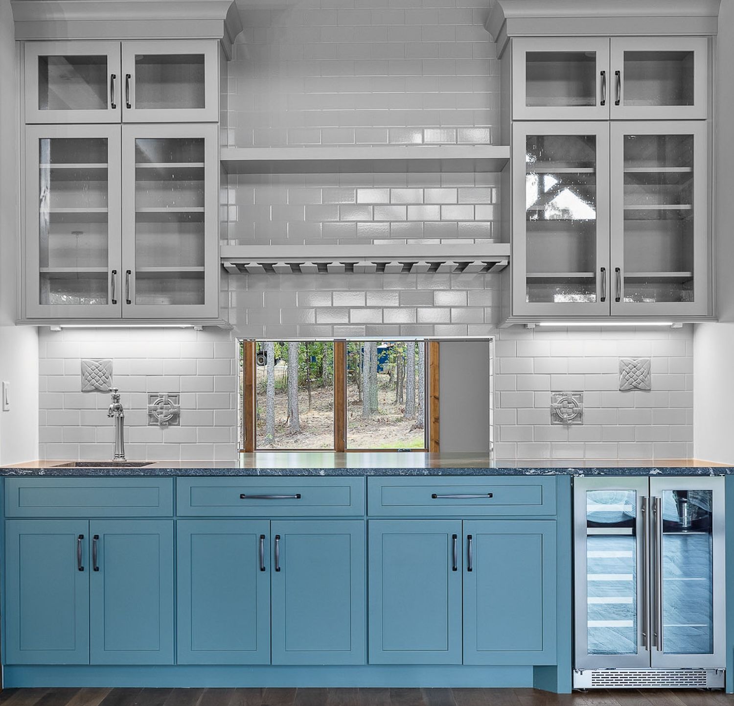 Blue and white kitchen with cabinets, a window, and a built-in wine cooler.