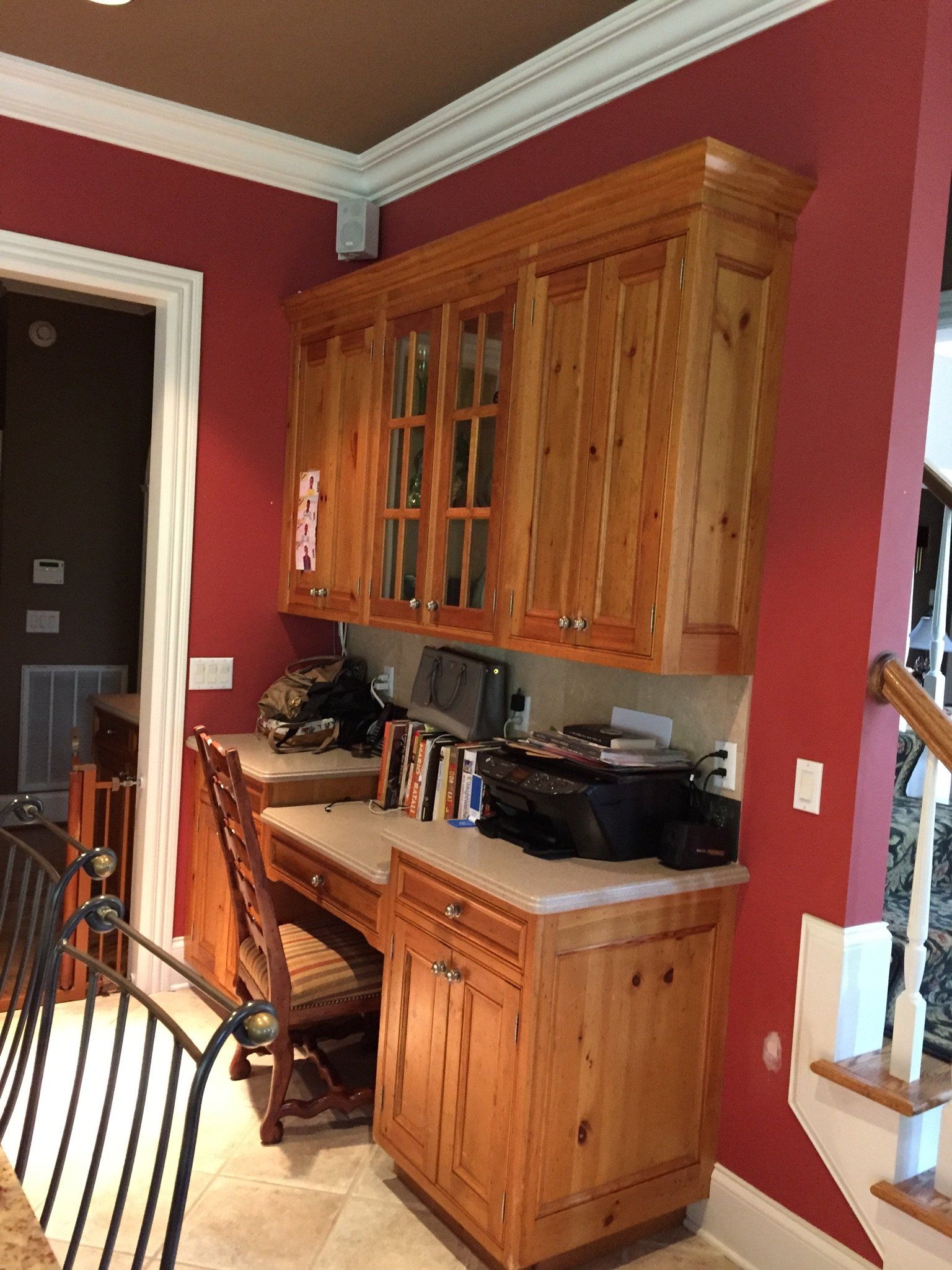 A kitchen with wooden cabinets and a desk with a printer on it