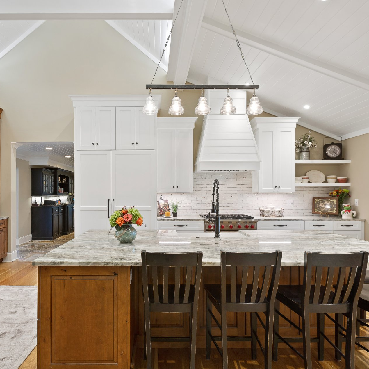 A kitchen with white cabinets and a large island